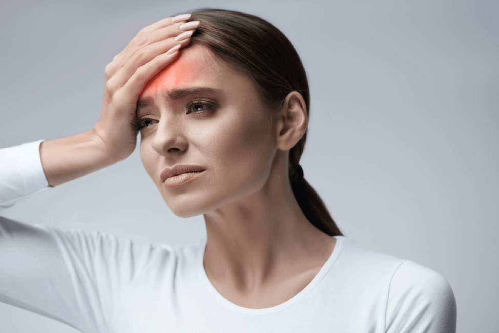A woman is holding her head in pain because of a headache.